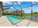 Screened pool with clear water overlooks a fenced backyard with a serene view of the adjacent pond at 3999 Burdick Loop, Odessa, FL 33556