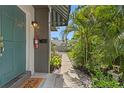 A teal door welcomes you, complemented by lush tropical landscaping, marking the inviting entrance to the home at 441 75Th N Ave, St Petersburg, FL 33702