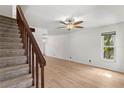 Bright living room with a ceiling fan, and the staircase is on the left side, with wood-look floors and ample natural light at 441 75Th N Ave, St Petersburg, FL 33702