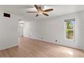 Open living room featuring wood-look floors, a ceiling fan, and a large window providing natural light at 441 75Th N Ave, St Petersburg, FL 33702