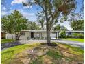 Inviting home with mature trees, lush lawn, and landscaping that enhances curb appeal at 4461 Shore Acres Ne Blvd, St Petersburg, FL 33703