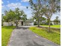 Beautifully landscaped property featuring a well-maintained lawn, mature trees, and a charming single-story home at 4461 Shore Acres Ne Blvd, St Petersburg, FL 33703