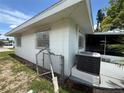 An exterior view of the house featuring a modern AC unit, fence, and screened porch at 4641 Carson Ne St, St Petersburg, FL 33703