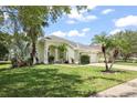 Beautifully landscaped single-story home with a well-manicured lawn and mature tropical landscaping at 4948 Ridgemoor Cir, Palm Harbor, FL 34685