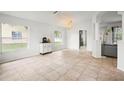 Bright living room features tile flooring, neutral walls, large windows, and chandelier lighting at 4948 Ridgemoor Cir, Palm Harbor, FL 34685