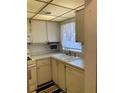 Bright kitchen area with a double sink, tiled backsplash, and white cabinetry at 5623 80Th N St # 314, St Petersburg, FL 33709