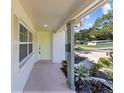 Covered front porch with a yellow door, lush plants, and decorative landscaping at 5998 8Th S St, St Petersburg, FL 33705