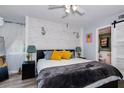 Cozy main bedroom featuring a wood accent wall, barn door to bathroom, and a comfortable queen-sized bed at 6932 Stones Throw N Cir # 7101, St Petersburg, FL 33710