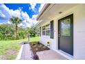 Inviting front entrance with decorative door, beautiful new landscaping, and a view of the water at 8001 N Highland Ave, Tampa, FL 33604