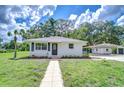 Charming single-story home with a well-manicured lawn, new landscaping, and a detached garage at 8001 N Highland Ave, Tampa, FL 33604