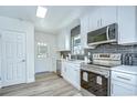 Bright kitchen features white cabinets, stainless steel appliances, and gray backsplash at 8001 N Highland Ave, Tampa, FL 33604