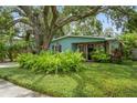 Charming home with lush green lawn and landscaped garden surrounding the facade at 8014 27Th N Ave, St Petersburg, FL 33710