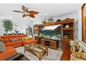 Spacious living room with tile floors, a large tv, and a comfortable orange couch at 8105 N Grady Ave, Tampa, FL 33614