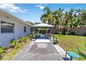 Well-maintained backyard featuring a covered gazebo with seating, lush landscaping, and tropical palm trees at 917 Pineview Ave, Clearwater, FL 33756