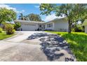 Charming single-story home featuring a well-manicured lawn and a two-car garage on a sunny day at 917 Pineview Ave, Clearwater, FL 33756