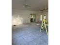 Renovations underway in a living room with an open floor plan, leading to the kitchen and a set of doors to the exterior at 103 9Th St, Belleair Beach, FL 33786