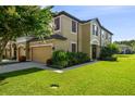 Inviting two-story townhome with lush landscaping, a well-manicured lawn, and a warm, welcoming facade at 11519 Crowned Sparrow Ln, Tampa, FL 33626
