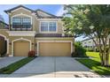 Two-story home boasts a spacious garage, beautiful landscaping, and a sunny front yard with flowering trees at 11519 Crowned Sparrow Ln, Tampa, FL 33626