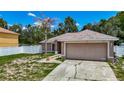 A single story home with neutral paint, arched windows, 2-car garage and concrete driveway at 13337 Tubeck St, Spring Hill, FL 34609