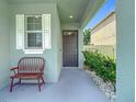Inviting front porch with a cozy bench and decorative plants at 13806 Reindeer Cir, Hudson, FL 34669