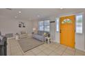 Inviting living room with tile flooring, neutral walls, and bright yellow front door at 1426 Gerard Ln, Holiday, FL 34690