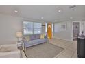Open concept living room with tile flooring, neutral walls, and bright yellow front door at 1426 Gerard Ln, Holiday, FL 34690