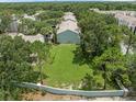 An aerial view of townhouse community with large grassy area, landscaping, and fencing at 2314 Lake Woodberry Cir, Brandon, FL 33510