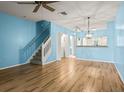 Open living space with sleek wood floors, staircase, pendant lighting, and open view to kitchen at 2314 Lake Woodberry Cir, Brandon, FL 33510