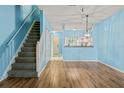 Open living space with sleek wood floors, staircase, pendant lighting, and open view to kitchen at 2314 Lake Woodberry Cir, Brandon, FL 33510