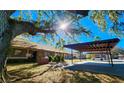 Exterior view showcasing a carport attached to a brick townhome with a tree providing shade at 35140 Whispering Oaks Blvd, Dade City, FL 33523