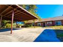 View of carports in front of brick homes with shade trees and well-maintained landscaping at 35140 Whispering Oaks Blvd, Dade City, FL 33523