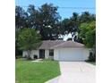 Charming one-story home with a well-manicured lawn, traditional details, and an attached garage at 401 Fern Cliff Ave, Temple Terrace, FL 33617