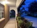 Welcoming front porch with stone archway and vibrant plants adds curb appeal to this lovely home at 402 Evergreen Dr, Oldsmar, FL 34677