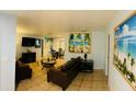 Inviting living room featuring tile flooring, comfortable leather furniture and tropical themed artwork at 402 Evergreen Dr, Oldsmar, FL 34677