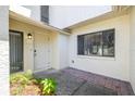 Charming entryway with a white front door, brick accents, and lush landscaping at 498 Lakeview Dr # 45, Palm Harbor, FL 34683