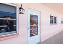 Exterior of a unit's front door with windows and a lantern-style light fixture at 6025 Shore S Blvd # 408, Gulfport, FL 33707