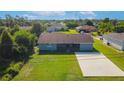 Backyard view shows spacious lawn and rear exterior with a concrete patio at 7061 Denmark St, Englewood, FL 34224