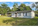 Well-maintained single-story home with tidy landscaping, dark shutters, and a manicured lawn at 8017 Tudor Pl, Tampa, FL 33610
