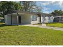 Single-story home with a covered carport, tidy landscaping, and a well-maintained lawn at 8017 Tudor Pl, Tampa, FL 33610