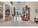 Bright living room with high ceilings, elegant decor, marble floors, and floor to ceiling windows at 8707 Silverthorn Rd, Seminole, FL 33777