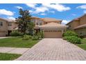 Charming two-story home featuring a tile roof, manicured landscaping, and an attached two-car garage at 10921 Cory Lake Dr, Tampa, FL 33647