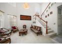 Bright living room with high ceilings, a chandelier, and staircase with wood trim at 10921 Cory Lake Dr, Tampa, FL 33647
