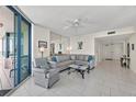 Bright living room with tile floors, ceiling fan, sliding glass doors and comfortable seating at 1540 Gulf Blvd # 2107, Clearwater Beach, FL 33767