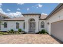 Elegant front entrance with a paver walkway and meticulously landscaped garden beds at 16304 Wild Mallard Dr, Odessa, FL 33556