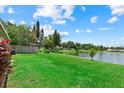 Spacious backyard featuring a lush green lawn and a serene lake view at 1741 Elk Spring Dr, Brandon, FL 33511