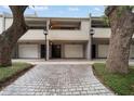 Charming townhouse exterior featuring a private garage and a welcoming entrance amidst lush greenery at 301 2Nd N St # 14, St Petersburg, FL 33701