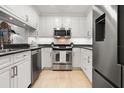 Updated kitchen features stainless steel appliances, white cabinetry, and granite countertops at 301 2Nd N St # 14, St Petersburg, FL 33701