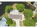 Aerial view of a home with a neutral roof, a long driveway, and mature landscaping at 336 Westwinds Cir, Palm Harbor, FL 34683