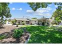 Expansive backyard with well-maintained lawn, mature trees, and a cozy covered patio at 336 Westwinds Cir, Palm Harbor, FL 34683