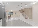 Open living area with tile flooring, staircase, and stainless steel refrigerator at 3368 Ramblewood Pl # 37-D-1, Sarasota, FL 34237